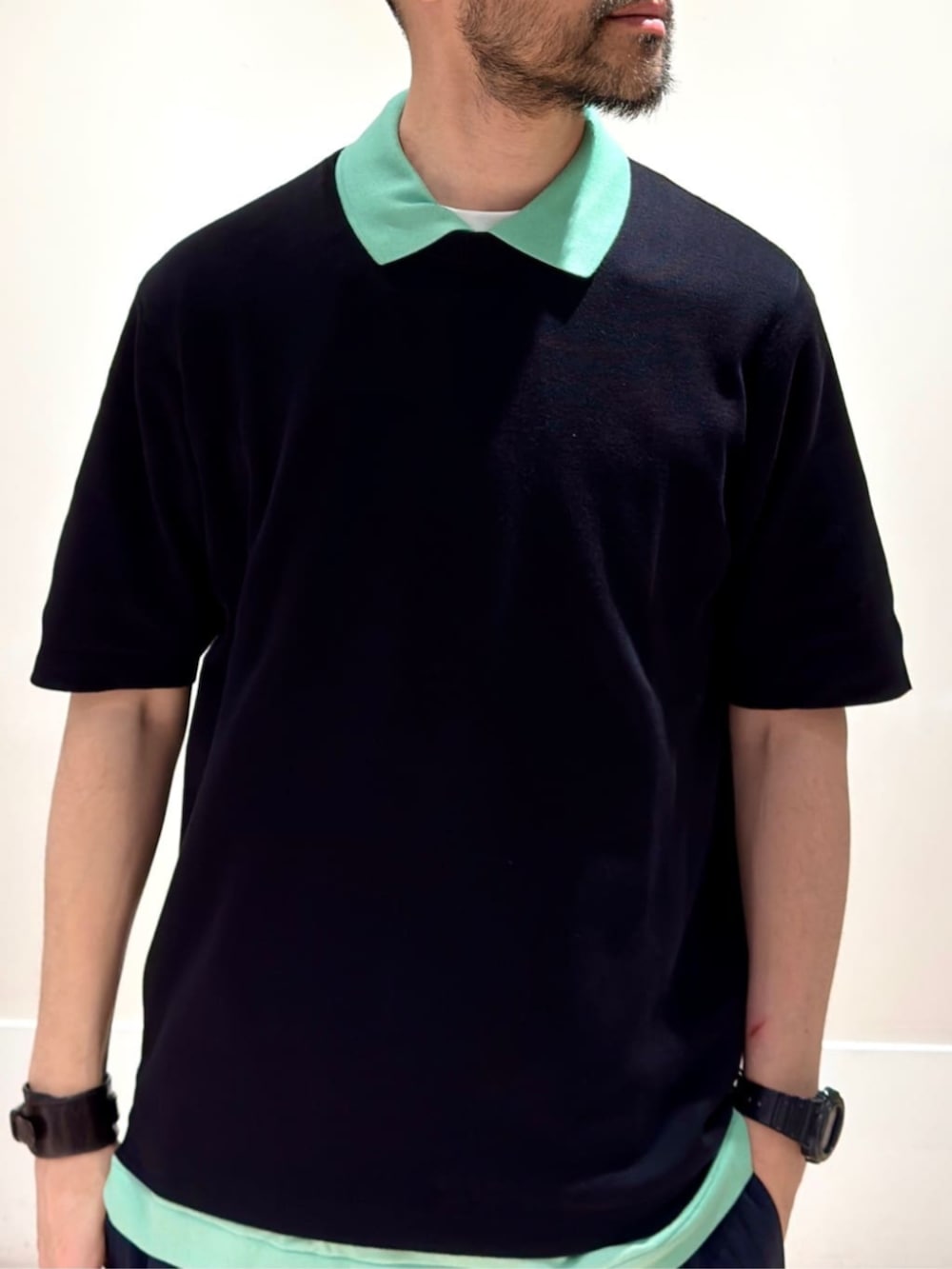 「TOMORROWLAND、トゥモローランド、LACOSTE、TOMORROWLAND tricot、シーアイランドコットン、ポロシャツ、グリーン、レイヤードスタイル、レザーリュック、レザーバックパック、カジュアル」｜「TOMORROWLAND のTOMORROWLAND Tricot シーアイランドコットン ハーフスリーブクルーネックニット（ニット/セーター、ブラック系）」を使った、Mashio_TOMORROWLANDさん（メンズ・175cm）の春コーディネートの2枚目の写真