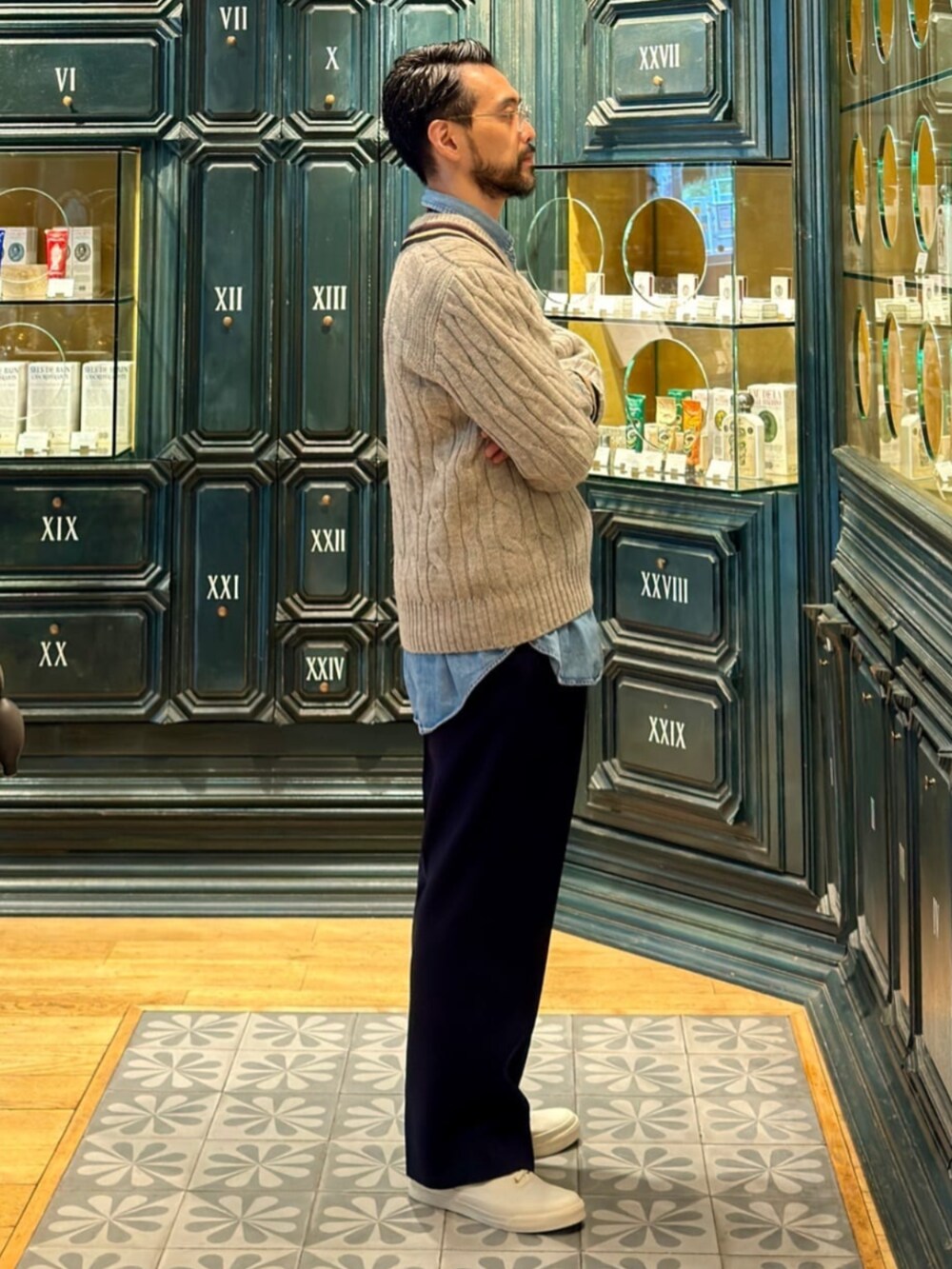 グレー系のニット/セーター、ブルー系のスラックスを着用したメンズの秋コーディネートの2枚目の写真