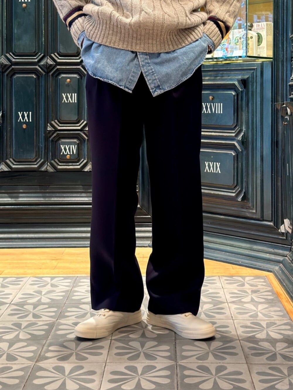 グレー系のニット/セーター、ブルー系のスラックスを着用したメンズの秋コーディネートの4枚目の写真