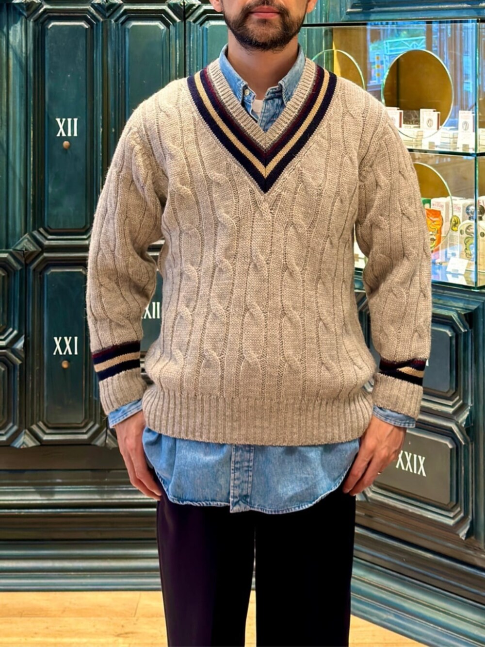 グレー系のニット/セーター、ブルー系のスラックスを着用したメンズの秋コーディネートの3枚目の写真