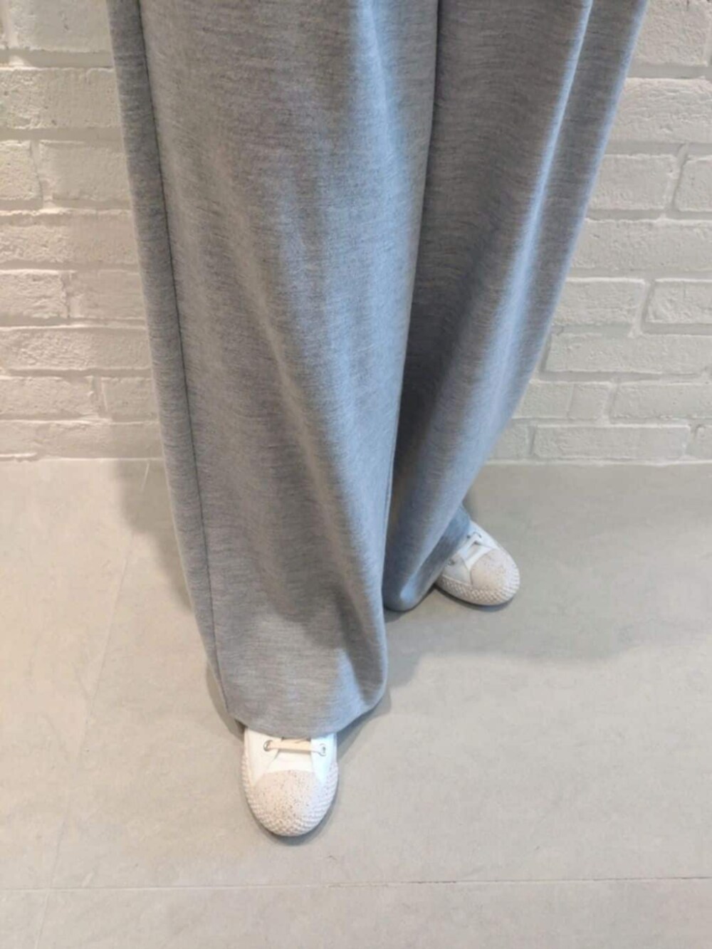 ホワイト系のTシャツ/カットソー、グレー系のその他パンツ、ホワイト系のニット/セーターを着用したレディースの冬コーディネートの6枚目の写真