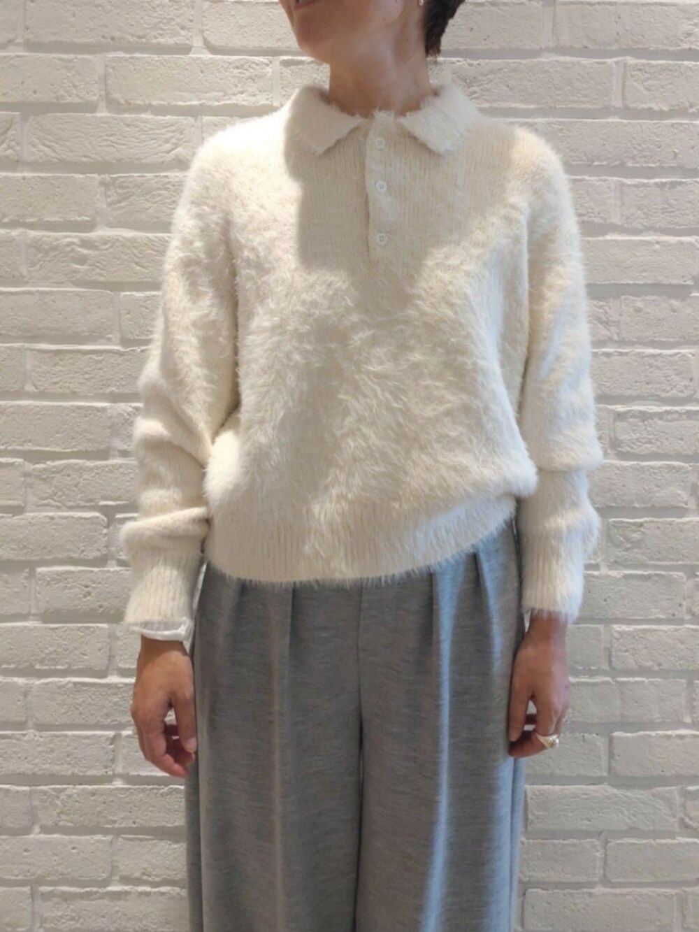 ホワイト系のTシャツ/カットソー、グレー系のその他パンツ、ホワイト系のニット/セーターを着用したレディースの冬コーディネートの4枚目の写真