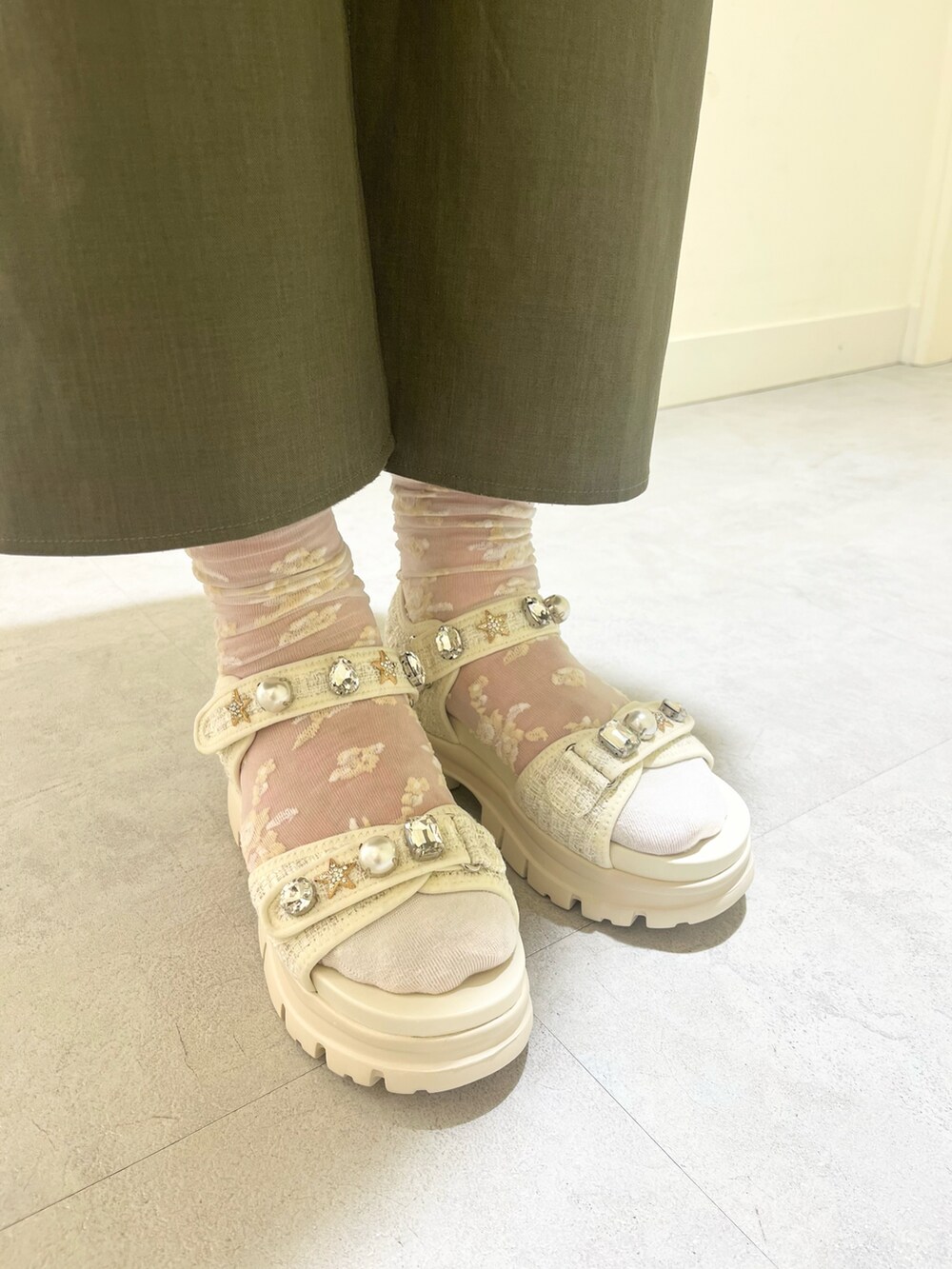 ホワイト系のサンダルを着用したレディースの春コーディネートの2枚目の写真