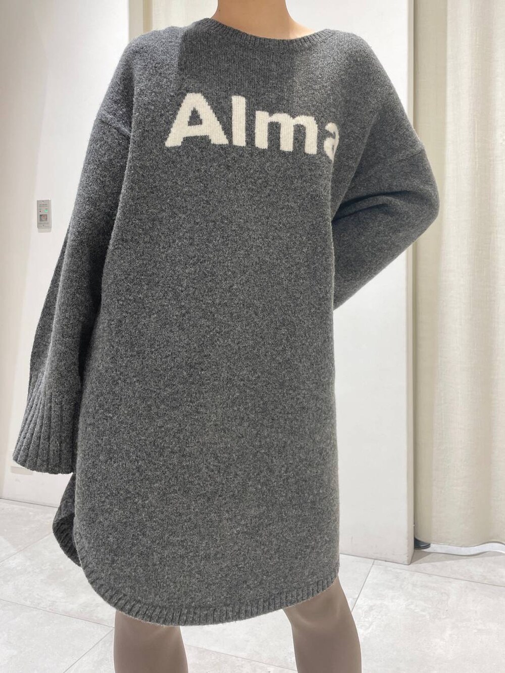 ブラック系のブーツ、グレー系のワンピース、ブラック系のニットキャップ/ビーニーを着用したレディースの冬コーディネートの4枚目の写真