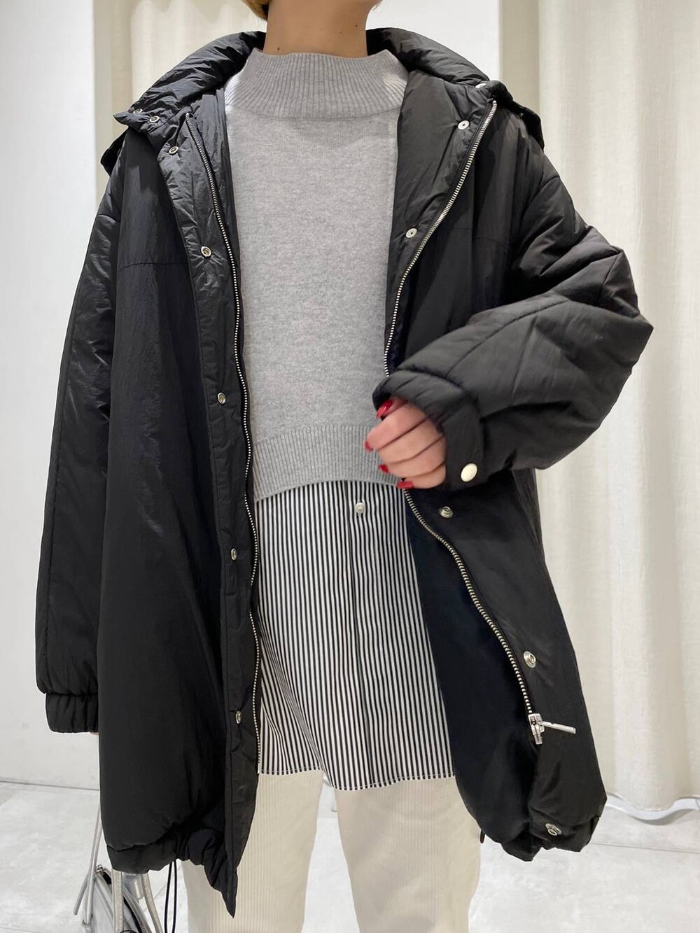 グレー系のブルゾン、ホワイト系のその他パンツ、グレー系のショルダーバッグを着用したレディースの冬コーディネートの2枚目の写真