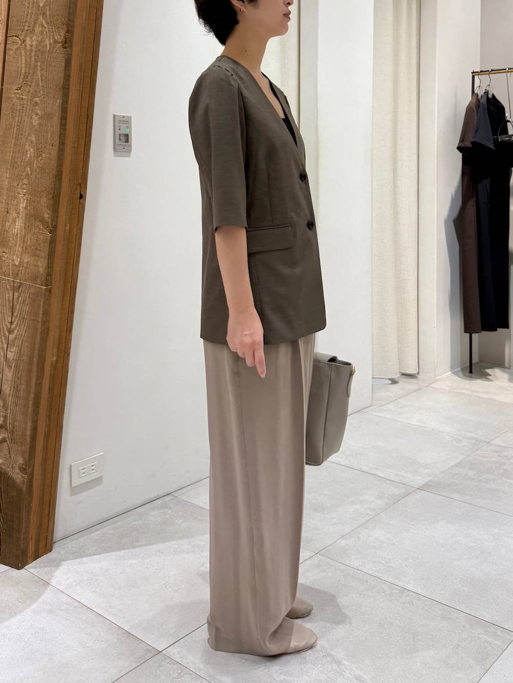 ベージュ系のパンプス、ブラウン系のノーカラージャケット、ベージュ系のスラックスを着用したレディースの春コーディネートの3枚目の写真