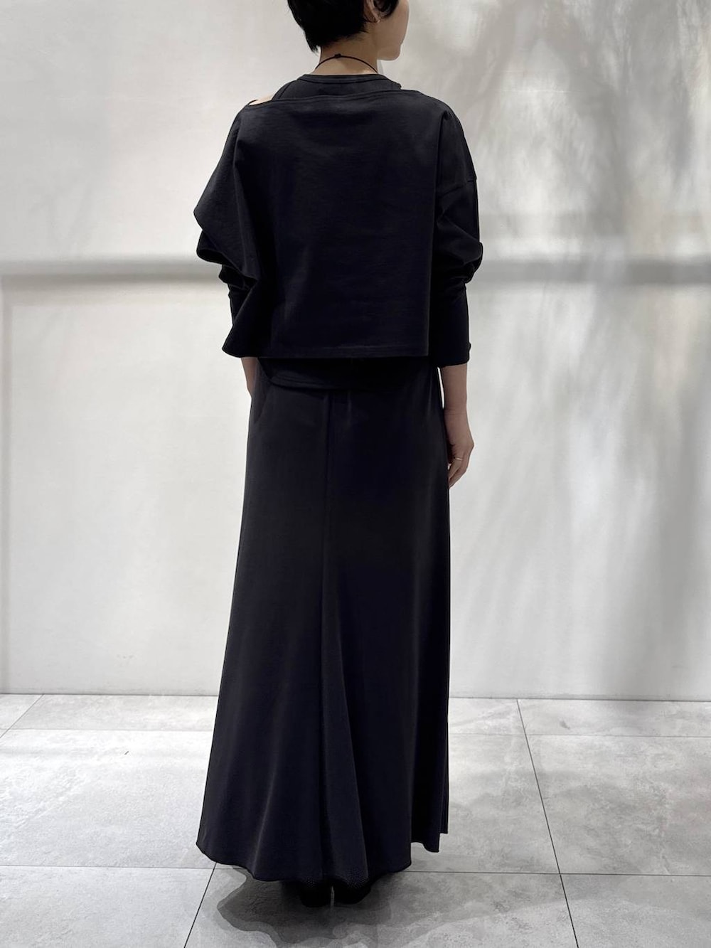 ブラック系のパンプス、グレー系のアンサンブル、グレー系のスカートを着用したレディースの春コーディネートの3枚目の写真