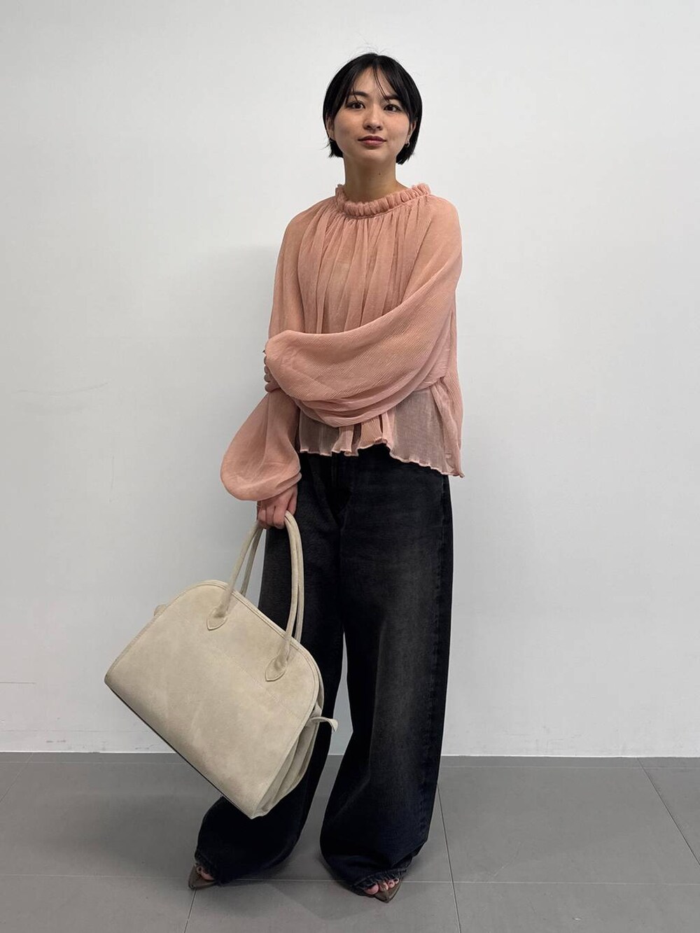 オレンジ系のキャミソール、ベージュ系のサンダル、ブラック系のデニムパンツを着用したレディースの夏コーディネートの2枚目の写真