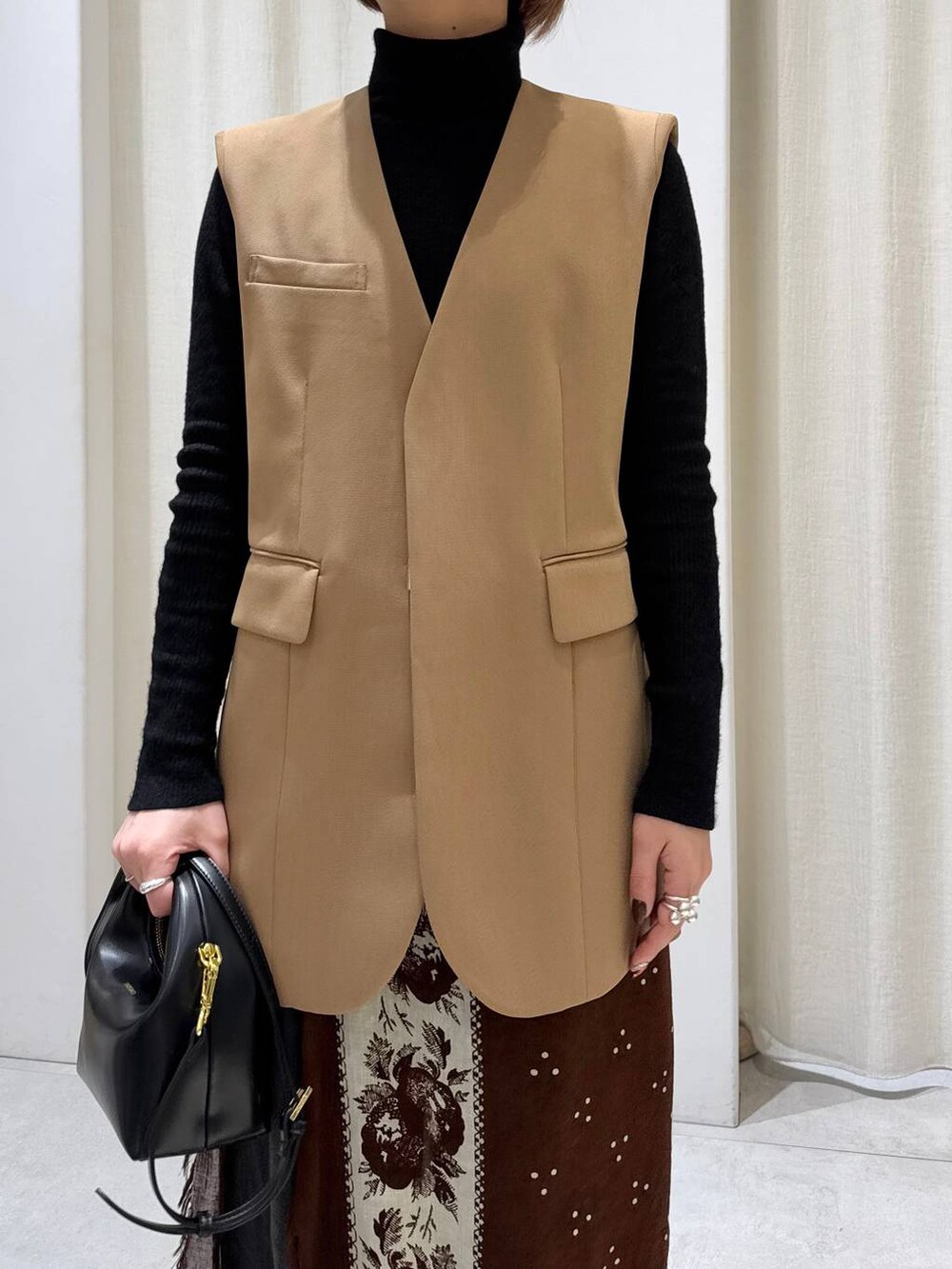 ブラック系のデニムパンツ、ベージュ系のその他アウター、ブラック系のショルダーバッグを着用したレディースの冬コーディネートの4枚目の写真