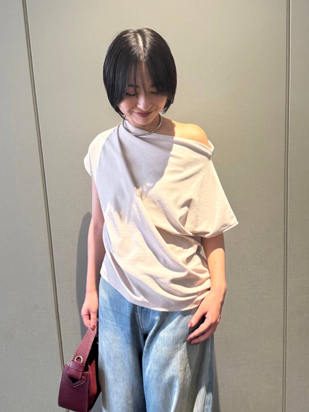 ブラック系のサンダル、ベージュ系のTシャツ/カットソー、ブルー系のデニムパンツを着用したレディースの夏コーディネートの6枚目の写真