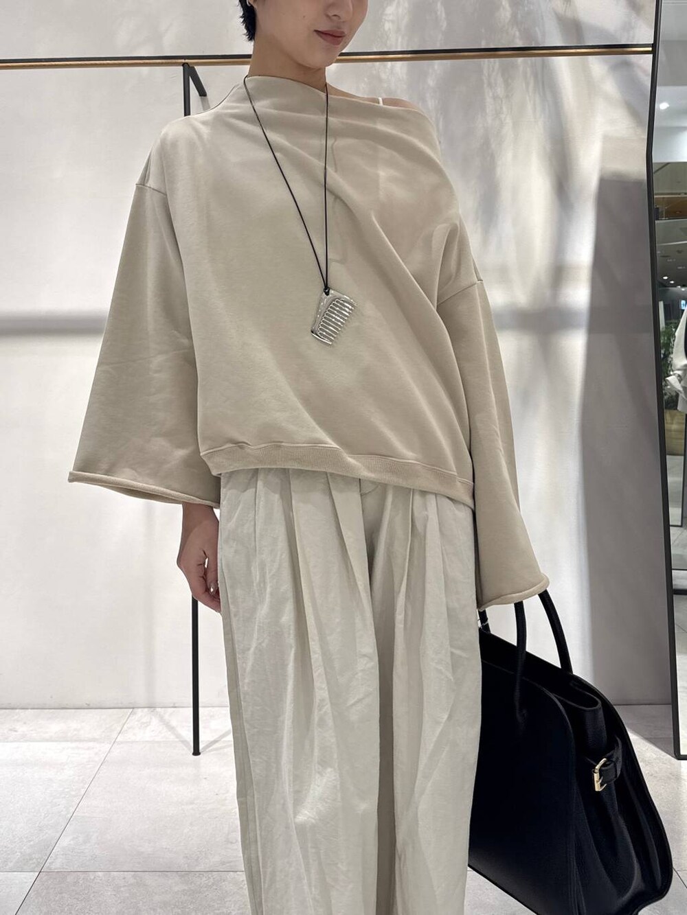 ベージュ系のスウェット、ブラック系のボストンバッグ、ベージュ系のその他パンツを着用したレディースの冬コーディネートの2枚目の写真