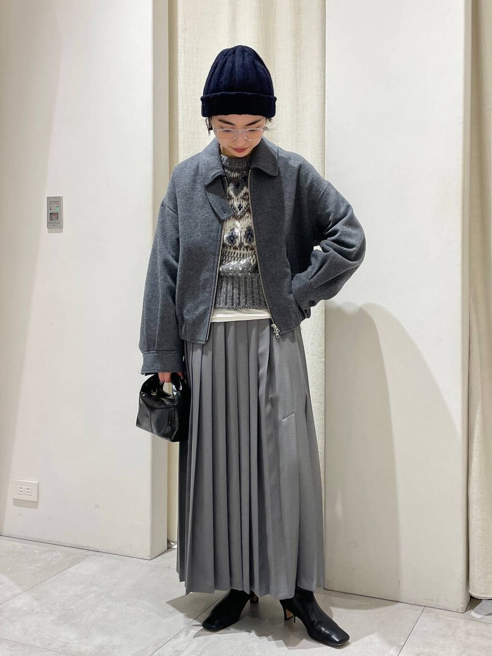 グレー系のニット/セーター、グレー系のスカート、グレー系のブルゾンを着用したレディースの秋コーディネートの3枚目の写真