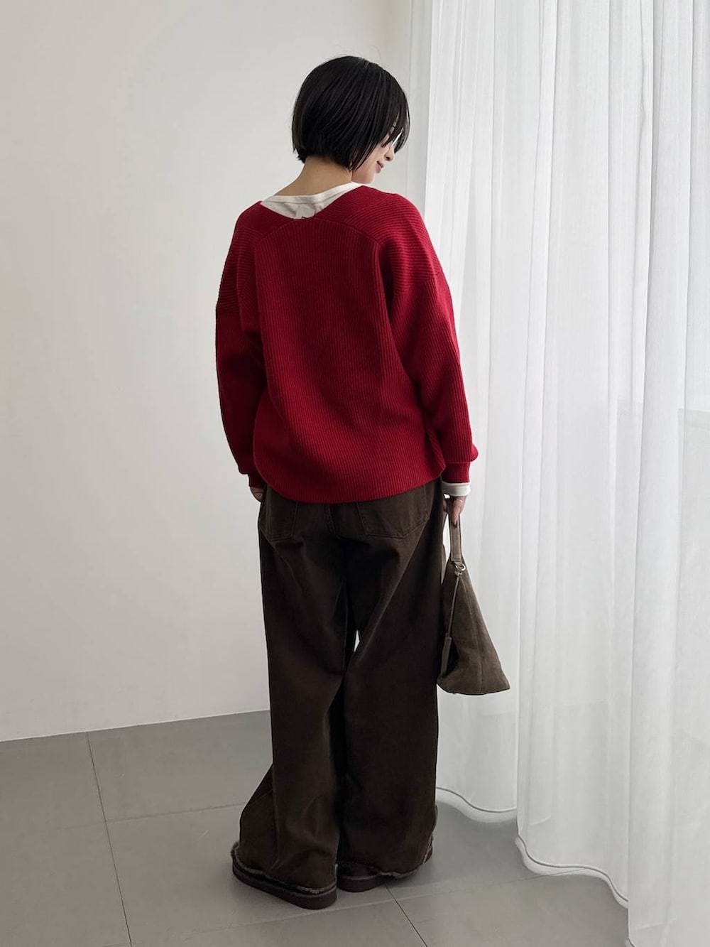 ホワイト系のTシャツ/カットソー、ブラウン系のサンダル、レッド系のニット/セーターを着用したレディースの秋コーディネートの3枚目の写真