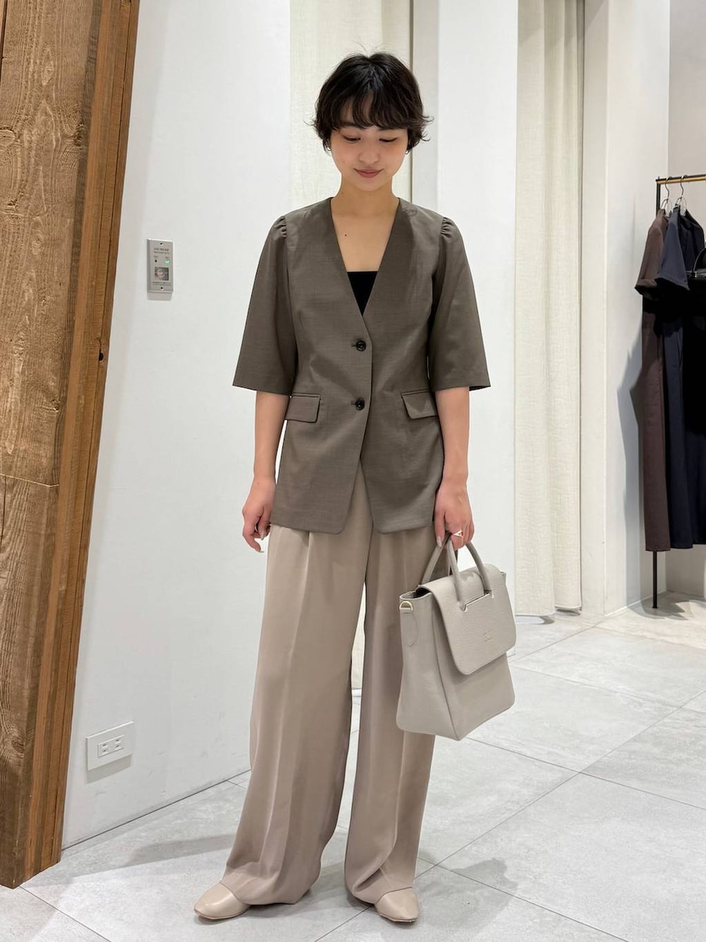 ベージュ系のパンプス、ブラウン系のノーカラージャケット、ベージュ系のスラックスを着用したレディースの春コーディネートの5枚目の写真