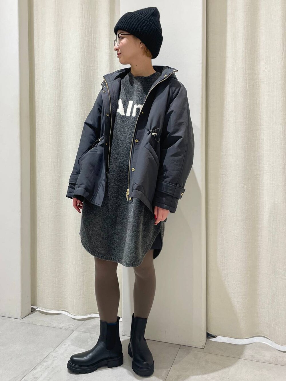 ブラック系のブーツ、グレー系のその他アウター、グレー系のワンピースを着用したレディースの冬コーディネートの2枚目の写真