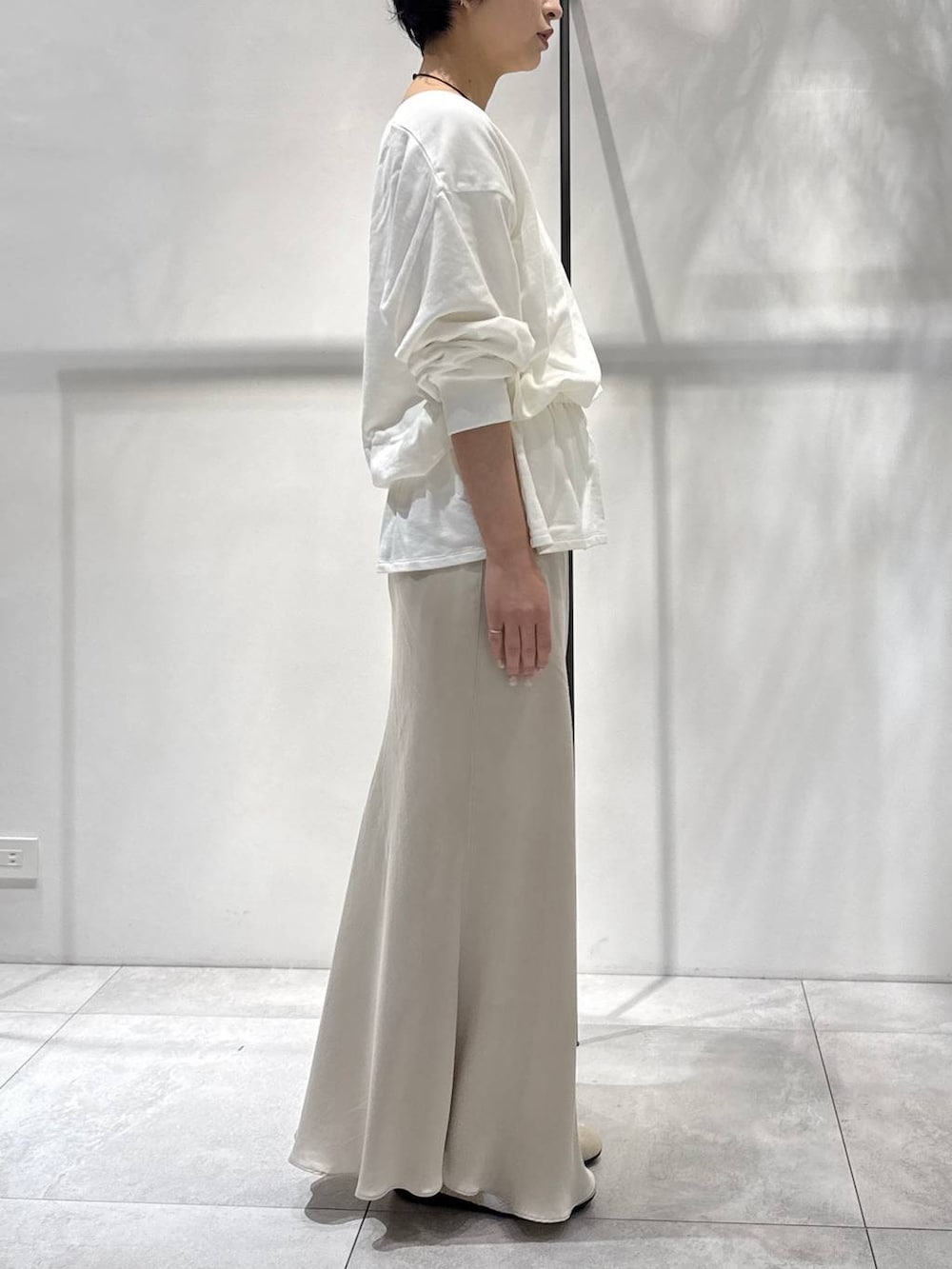 ベージュ系のスカート、ベージュ系のスニーカー、ホワイト系のスウェットを着用したレディースの春コーディネートの3枚目の写真