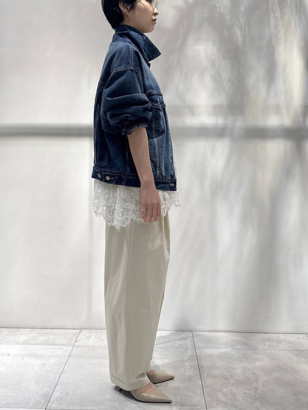 ホワイト系のキャミソール、ベージュ系のトレンチコート、ベージュ系のその他パンツを着用したレディースの冬コーディネートの3枚目の写真