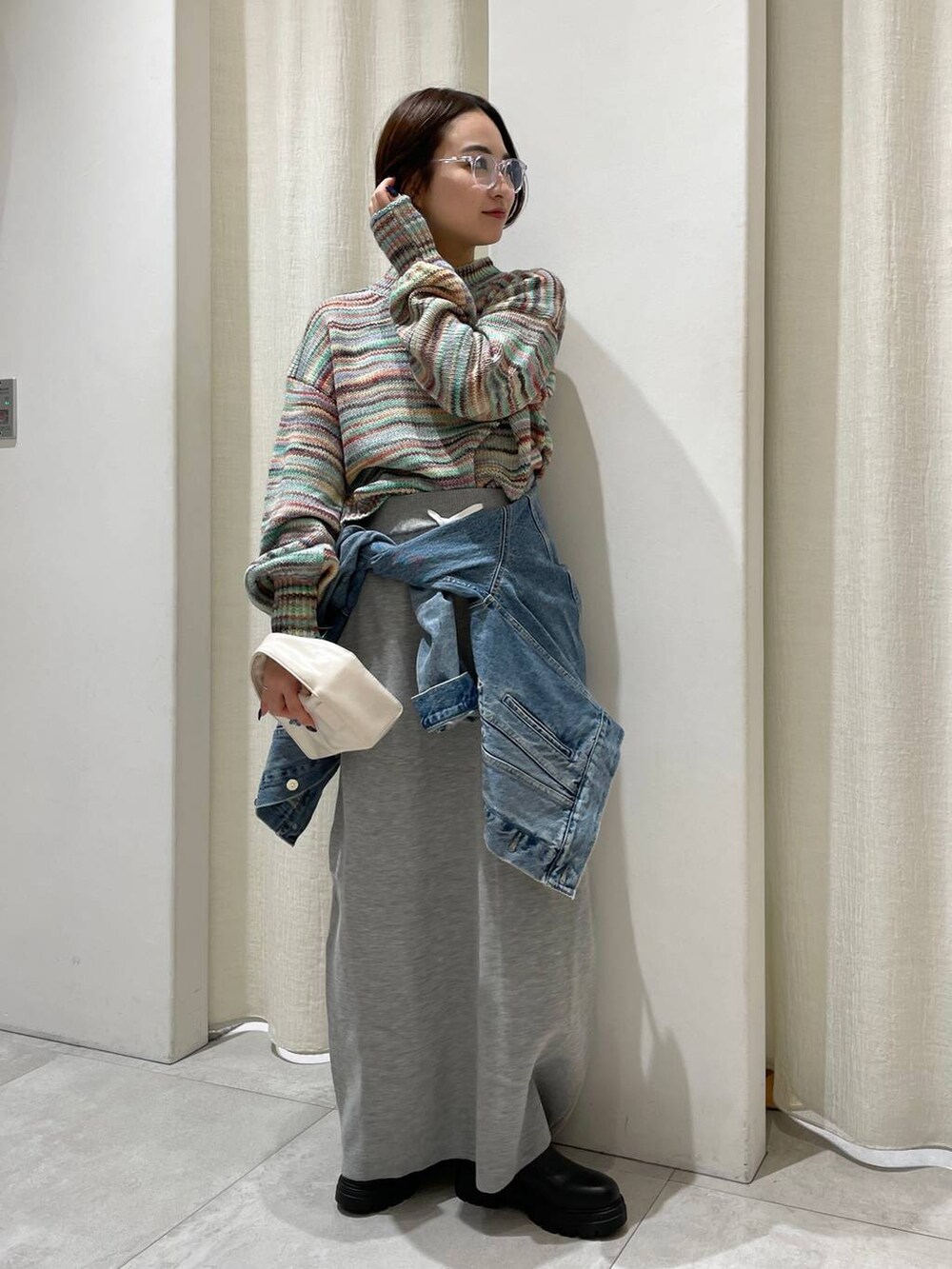 ブラック系のブーツ、ブルー系のデニムジャケット、グレー系のスカートを着用したレディースの秋コーディネートの4枚目の写真