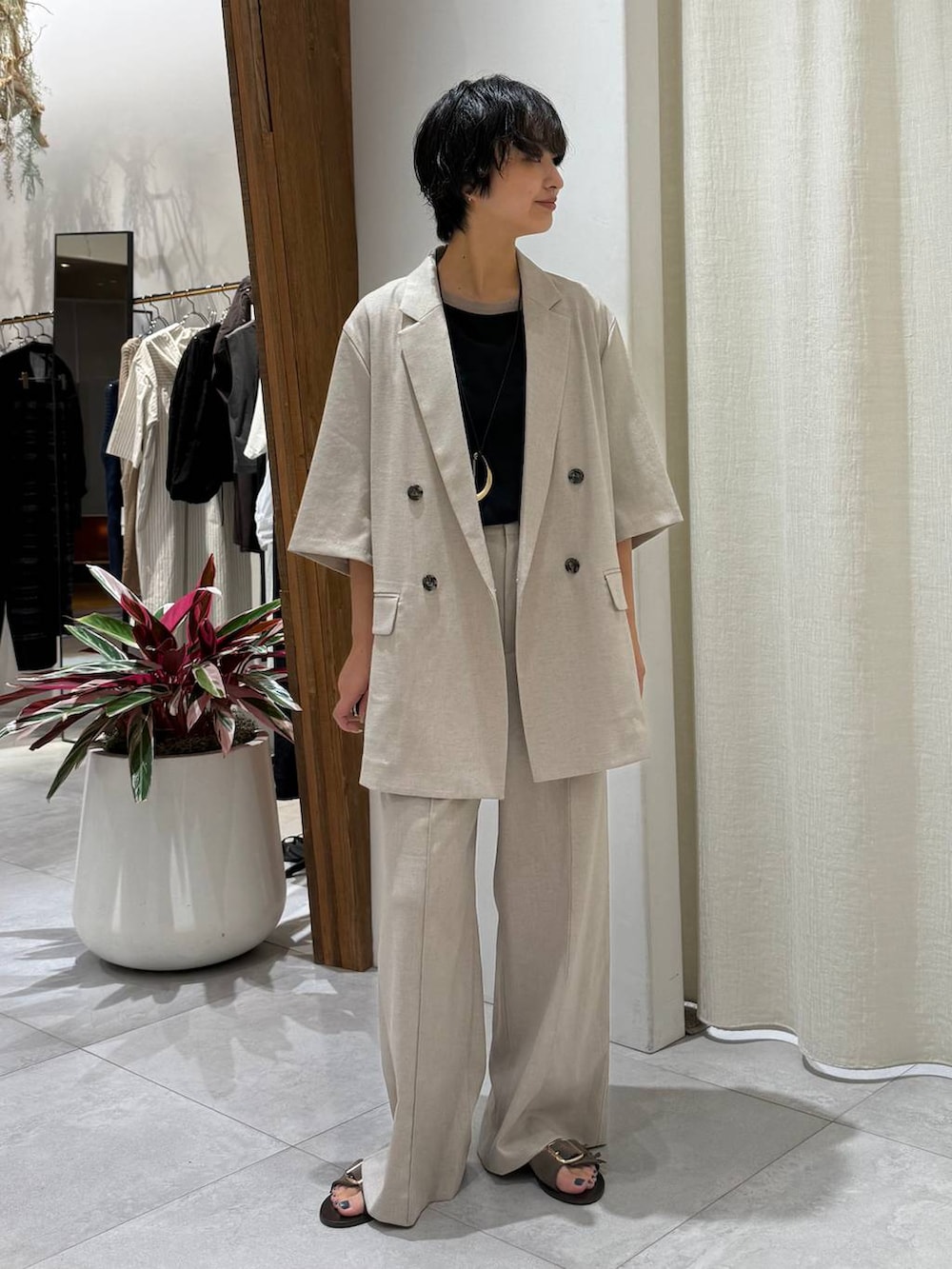 ベージュ系のスラックス、ベージュ系のテーラードジャケット、ブラック系のTシャツ/カットソーを着用したレディースの夏コーディネートの6枚目の写真