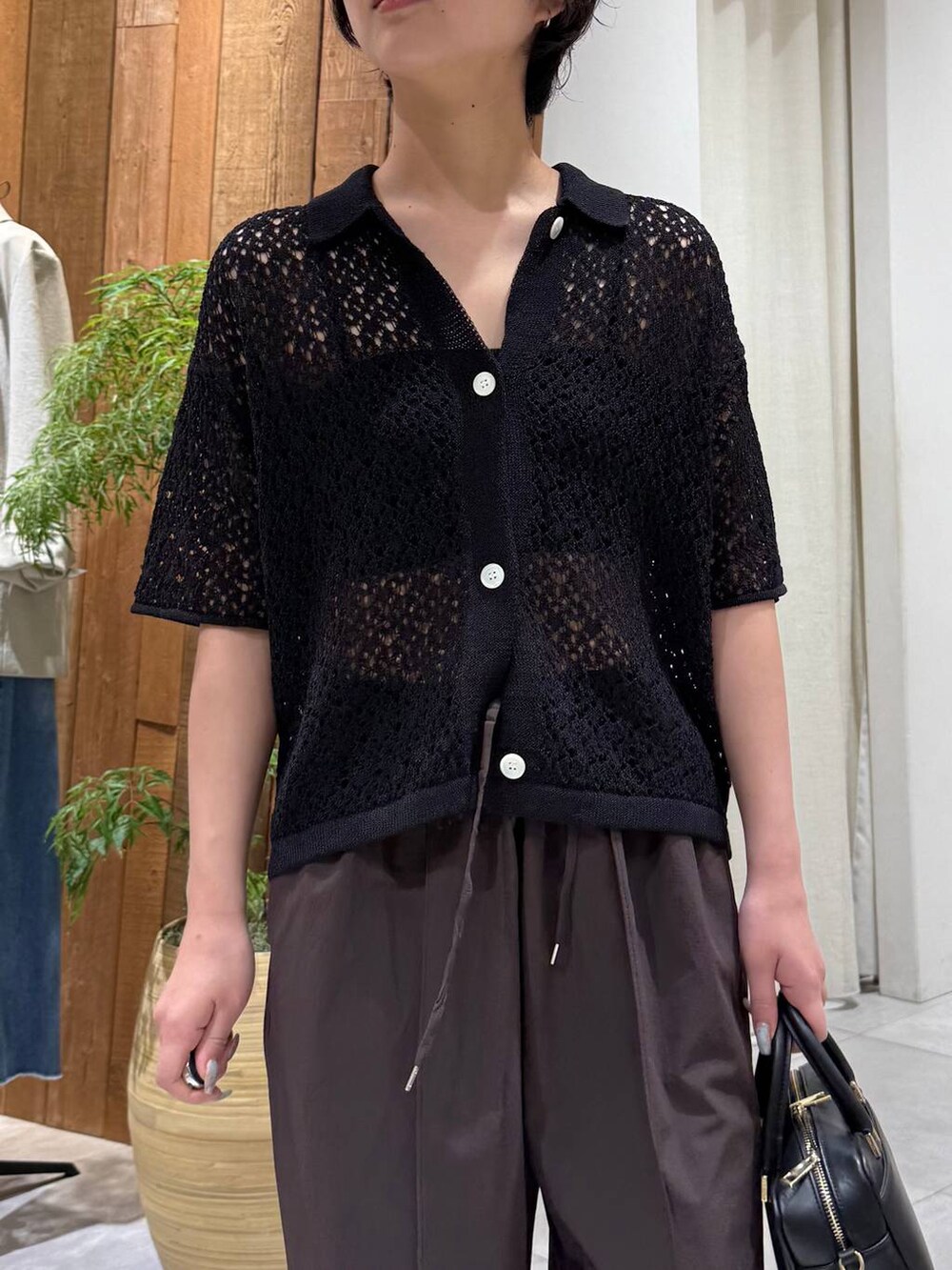 ブラウン系のその他パンツ、ブラック系のポロシャツを着用したレディースの春コーディネートの4枚目の写真