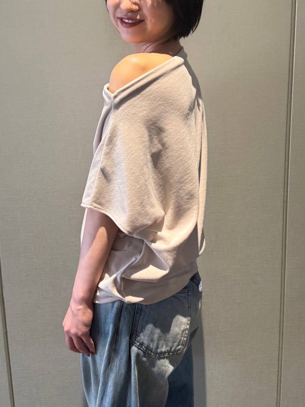 ブラック系のサンダル、ベージュ系のTシャツ/カットソー、ブルー系のデニムパンツを着用したレディースの夏コーディネートの5枚目の写真