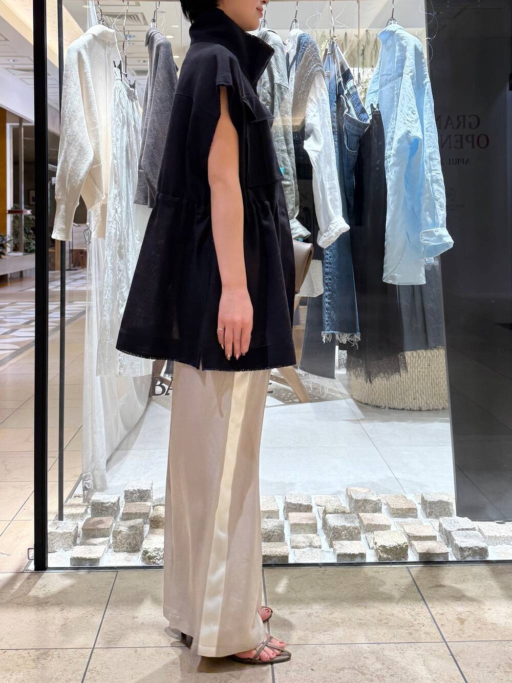 ベージュ系のその他パンツ、ベージュ系のサンダル、グレー系のベストを着用したレディースの春コーディネートの2枚目の写真