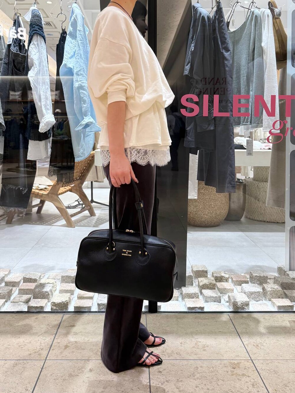 ブラック系のサンダル、ホワイト系のスウェット、ホワイト系のキャミソールを着用したレディースの春コーディネートの3枚目の写真