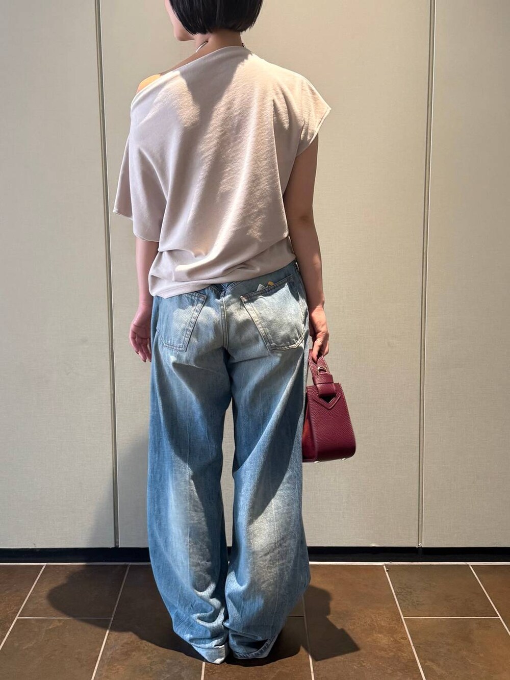 ブラック系のサンダル、ベージュ系のTシャツ/カットソー、ブルー系のデニムパンツを着用したレディースの夏コーディネートの3枚目の写真