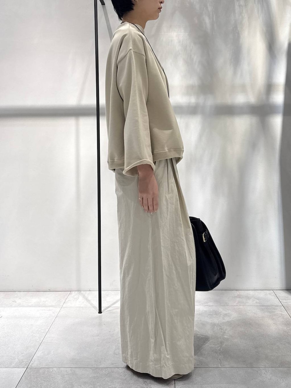 ベージュ系のスウェット、ブラック系のボストンバッグ、ベージュ系のその他パンツを着用したレディースの冬コーディネートの3枚目の写真