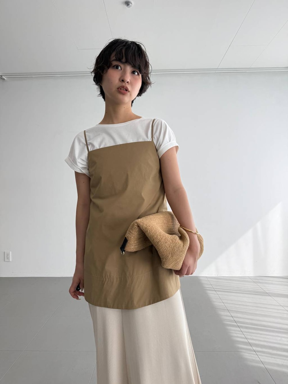 ホワイト系のTシャツ/カットソー、ベージュ系のスカート、ブラウン系のサンダルを着用したレディースの夏コーディネートの3枚目の写真