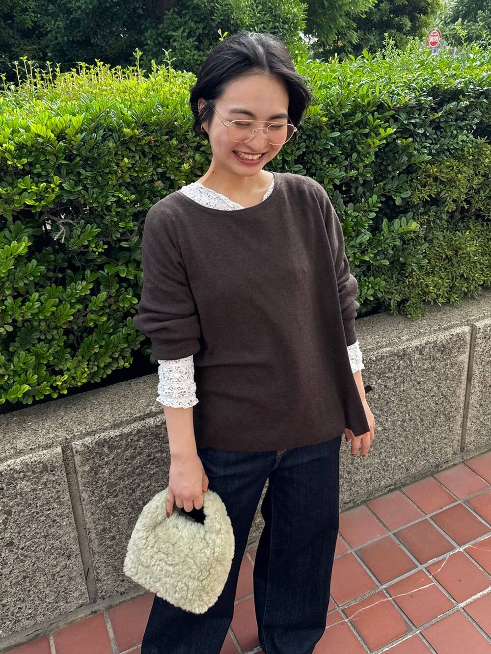 ホワイト系のTシャツ/カットソー、ブルー系のデニムパンツ、ブラウン系のニット/セーターを着用したレディースの夏コーディネートの4枚目の写真