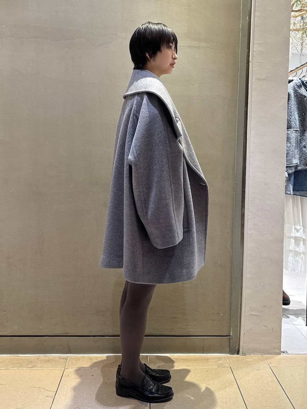 グレー系のニット/セーター、ベージュ系のハンドバッグ、グレー系のその他パンツを着用したレディースの秋コーディネートの2枚目の写真