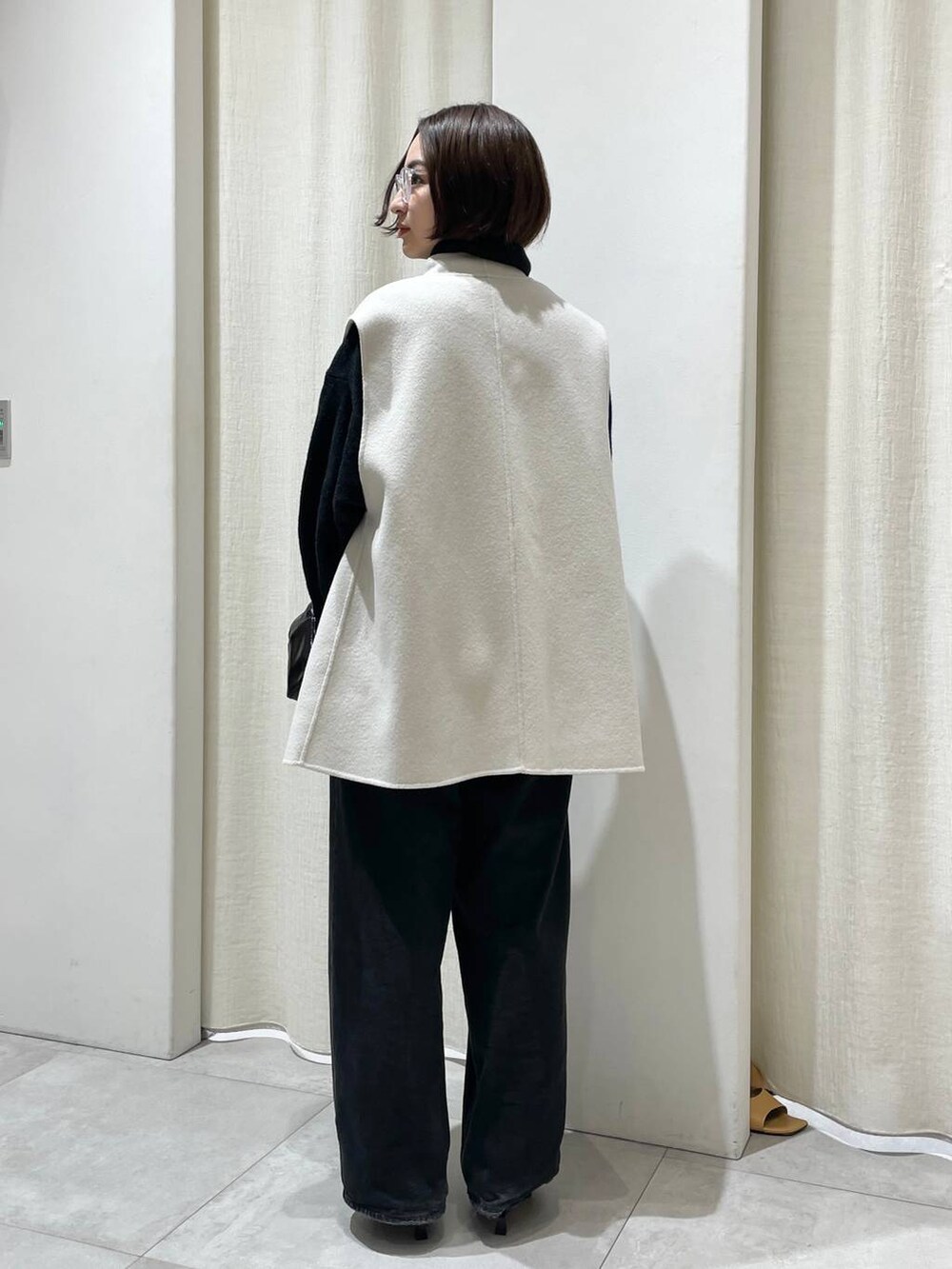 ブラック系のデニムパンツ、ホワイト系のその他アウター、グレー系のニット/セーターを着用したレディースの秋コーディネートの3枚目の写真