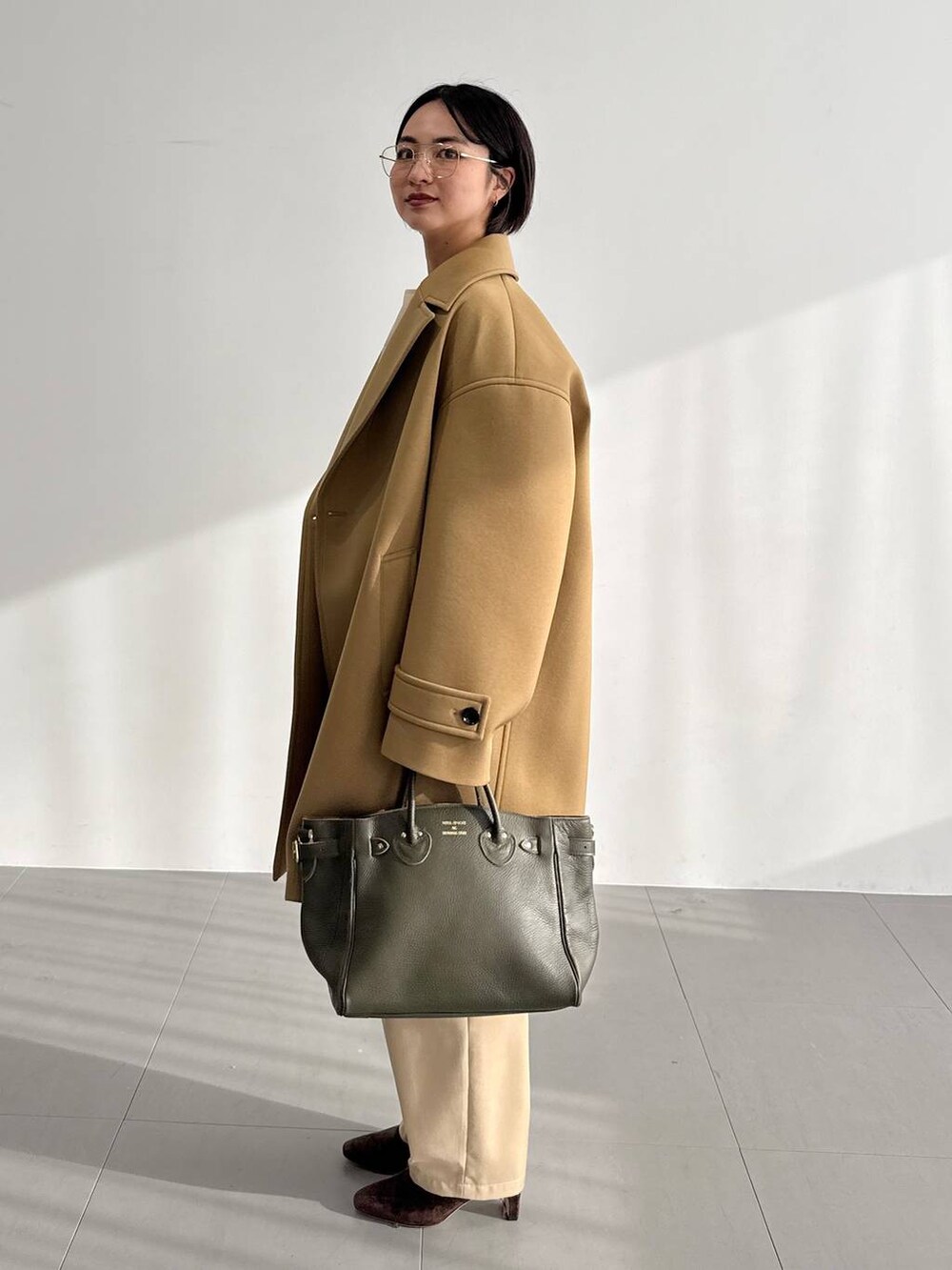 ベージュ系のその他パンツ、ベージュ系のピーコート、ブラウン系のブーツを着用したレディースの秋コーディネートの2枚目の写真