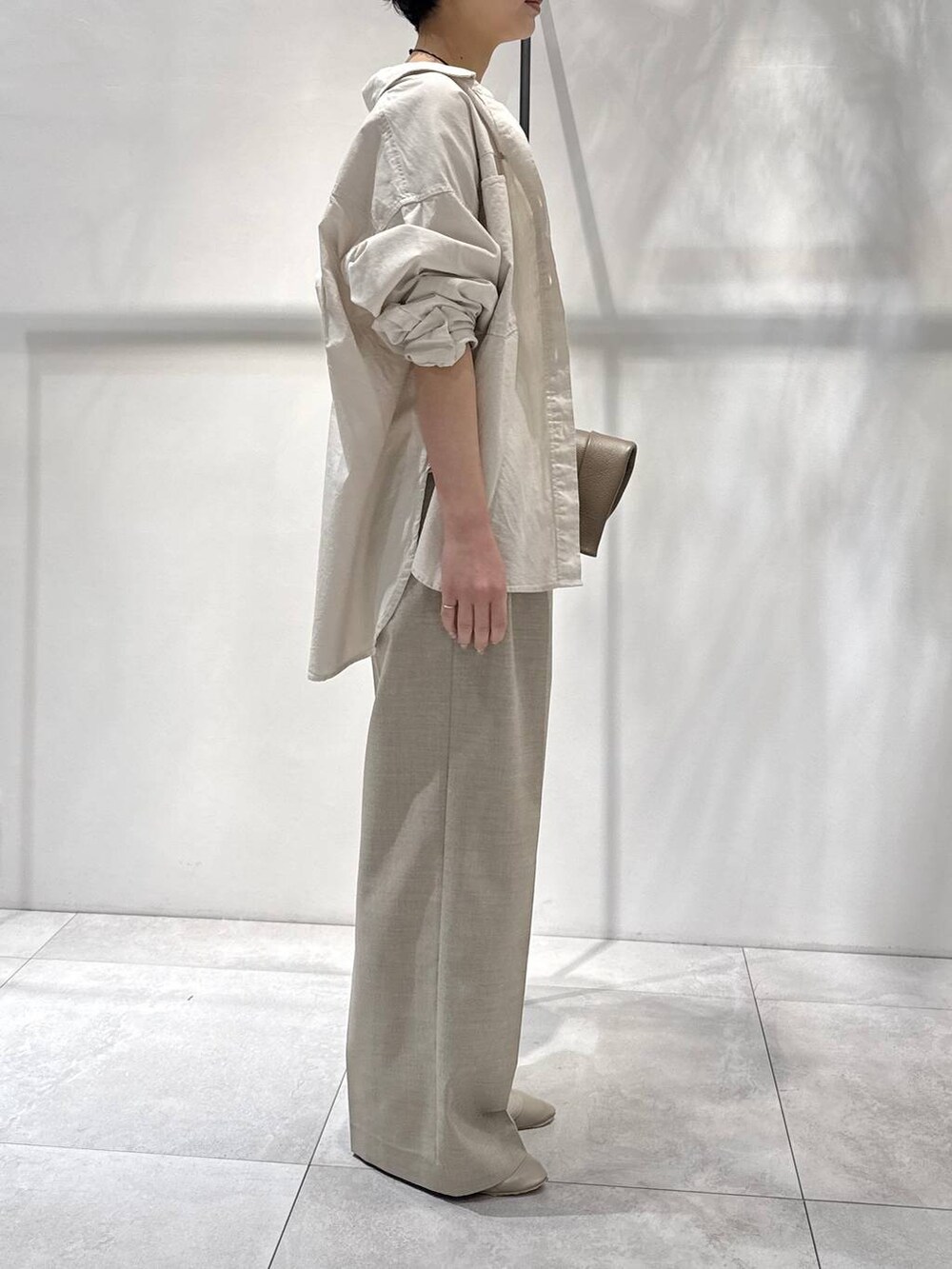 ベージュ系のシャツ/ブラウス、ベージュ系のパンプス、ベージュ系のスラックスを着用したレディースの春コーディネートの2枚目の写真