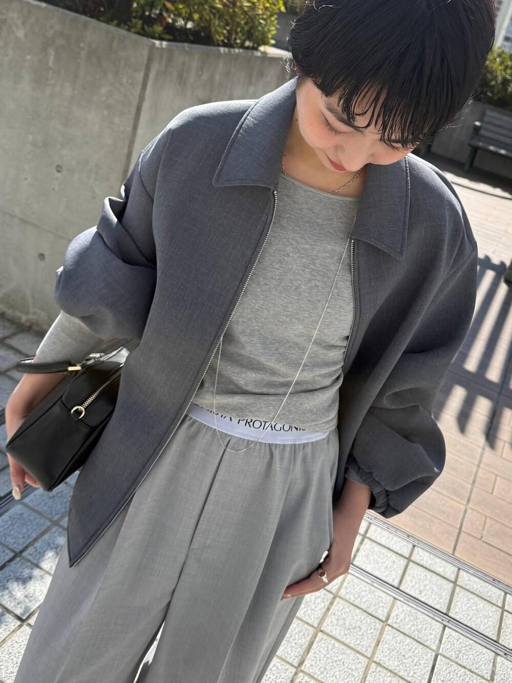 ブラック系のサンダル、グレー系のその他パンツ、グレー系のブルゾンを着用したレディースの冬コーディネートの2枚目の写真