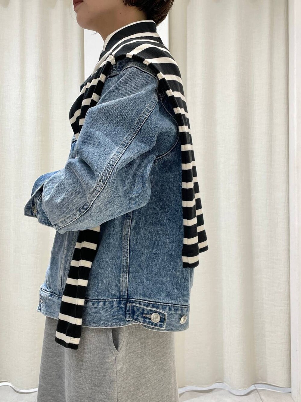 ブルー系のデニムジャケット、レッド系のショルダーバッグ、ブラック系のTシャツ/カットソーを着用したレディースの秋コーディネートの3枚目の写真