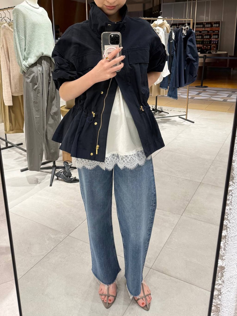 ベージュ系のサンダル、ブラウン系のハンドバッグ、ブルー系のブルゾンを着用したレディースの春コーディネートの4枚目の写真