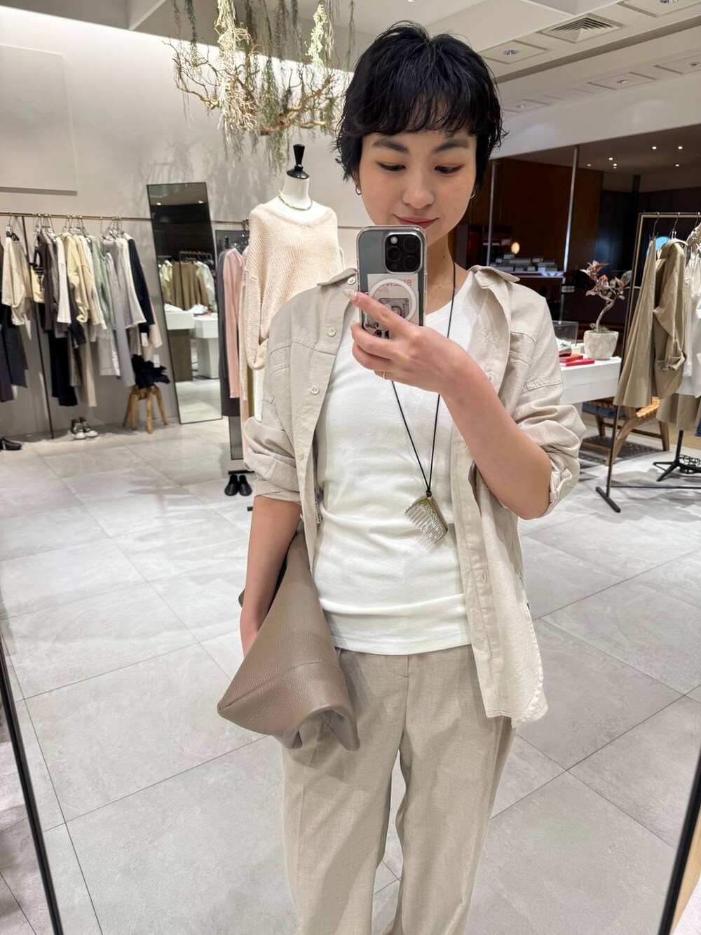 ベージュ系のシャツ/ブラウス、ベージュ系のパンプス、ベージュ系のスラックスを着用したレディースの春コーディネートの5枚目の写真