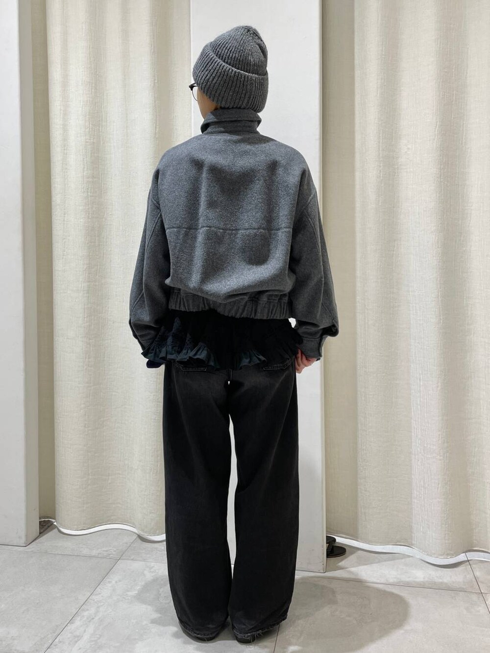 ブラック系のデニムパンツ、グレー系のブルゾン、ブルー系のニット/セーターを着用したレディースの冬コーディネートの4枚目の写真