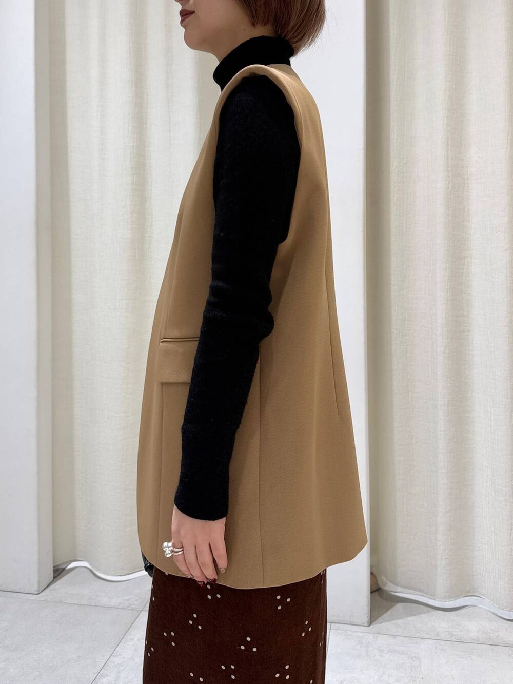 ブラック系のデニムパンツ、ベージュ系のその他アウター、ブラック系のショルダーバッグを着用したレディースの冬コーディネートの5枚目の写真