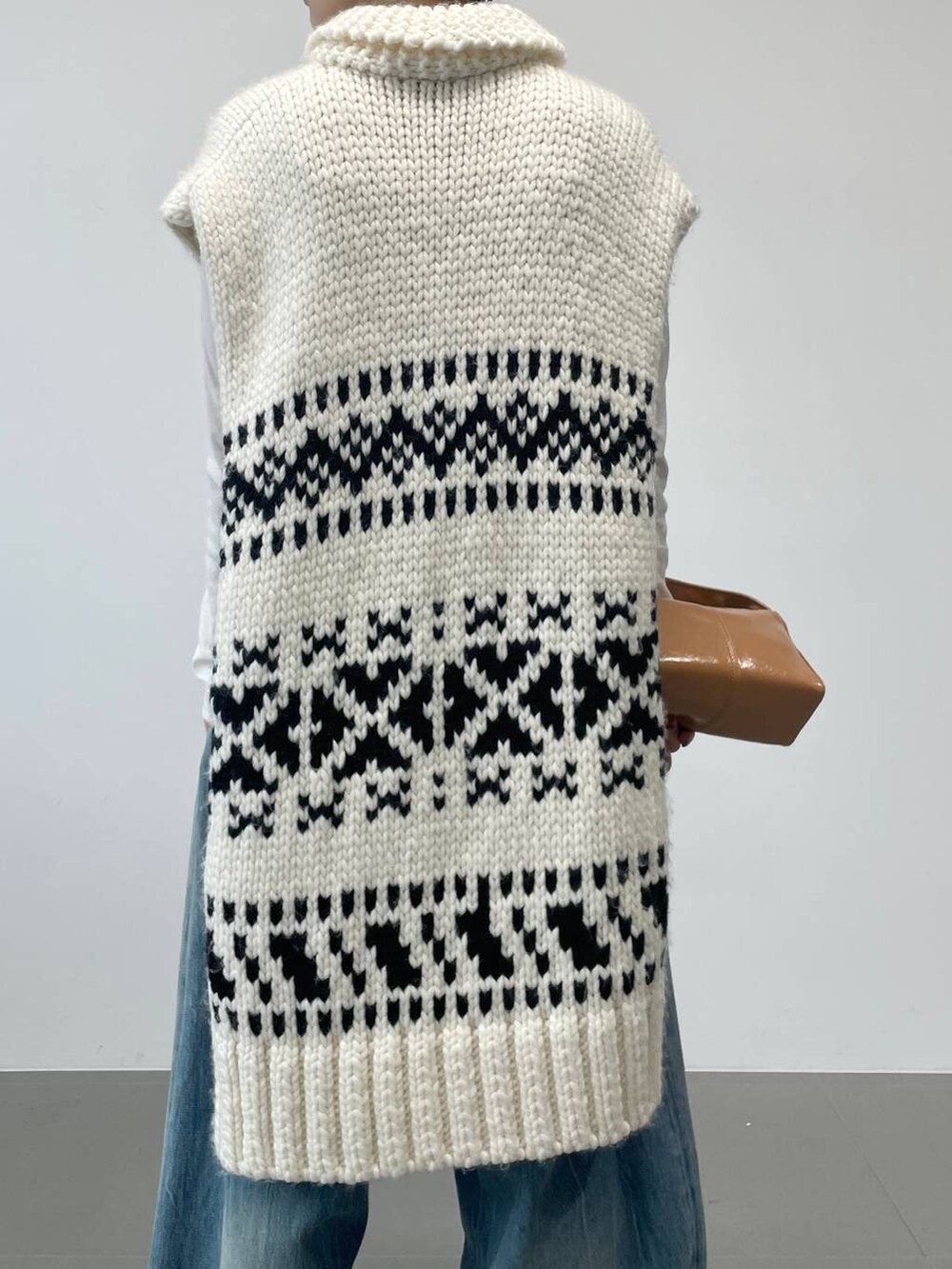 ブルー系のデニムパンツ、ホワイト系のTシャツ/カットソー、ホワイト系のベストを着用したレディースの秋コーディネートの4枚目の写真