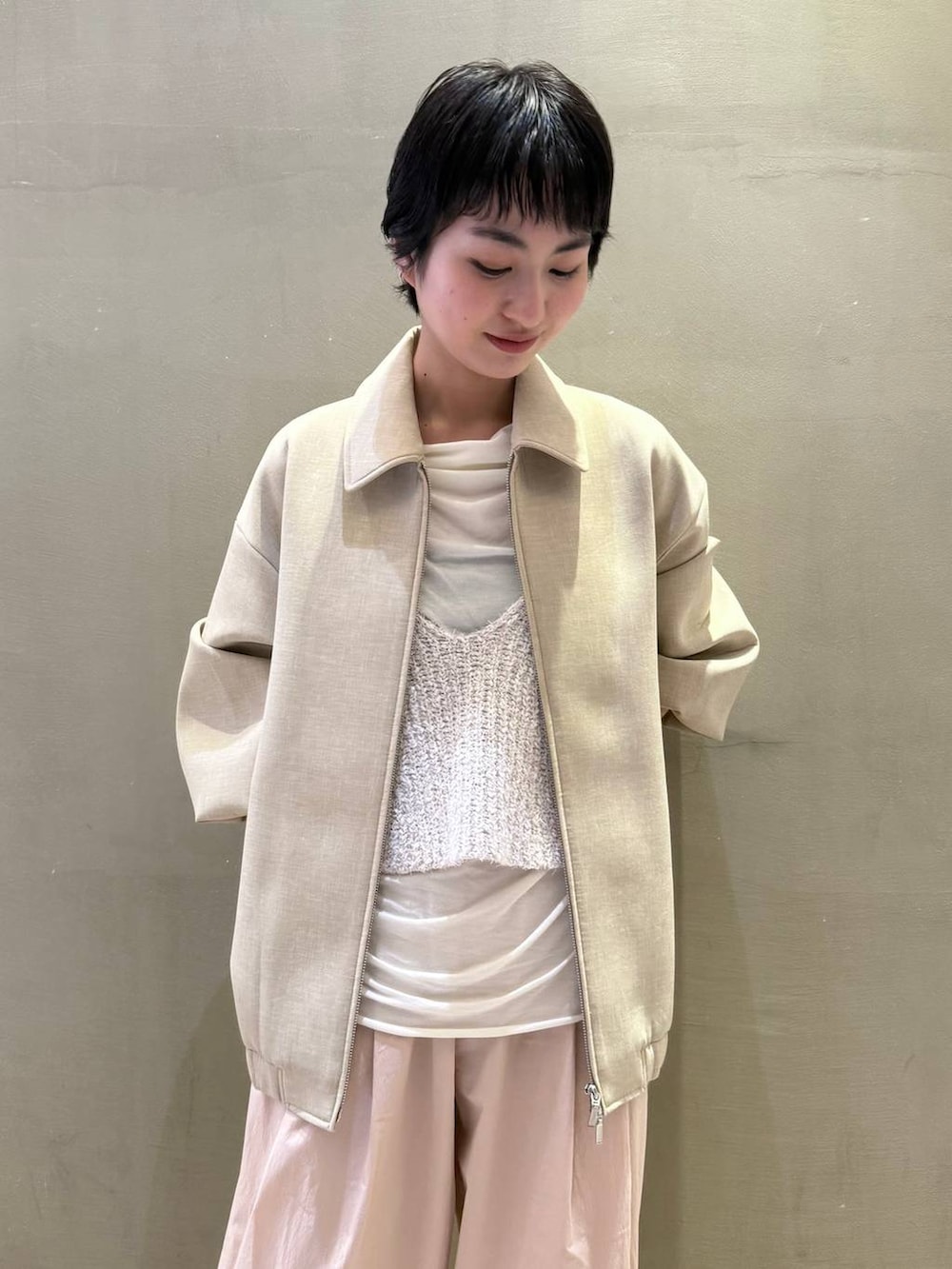 ベージュ系のキャミソール、ホワイト系のTシャツ/カットソー、ベージュ系のブルゾンを着用したレディースの冬コーディネートの3枚目の写真