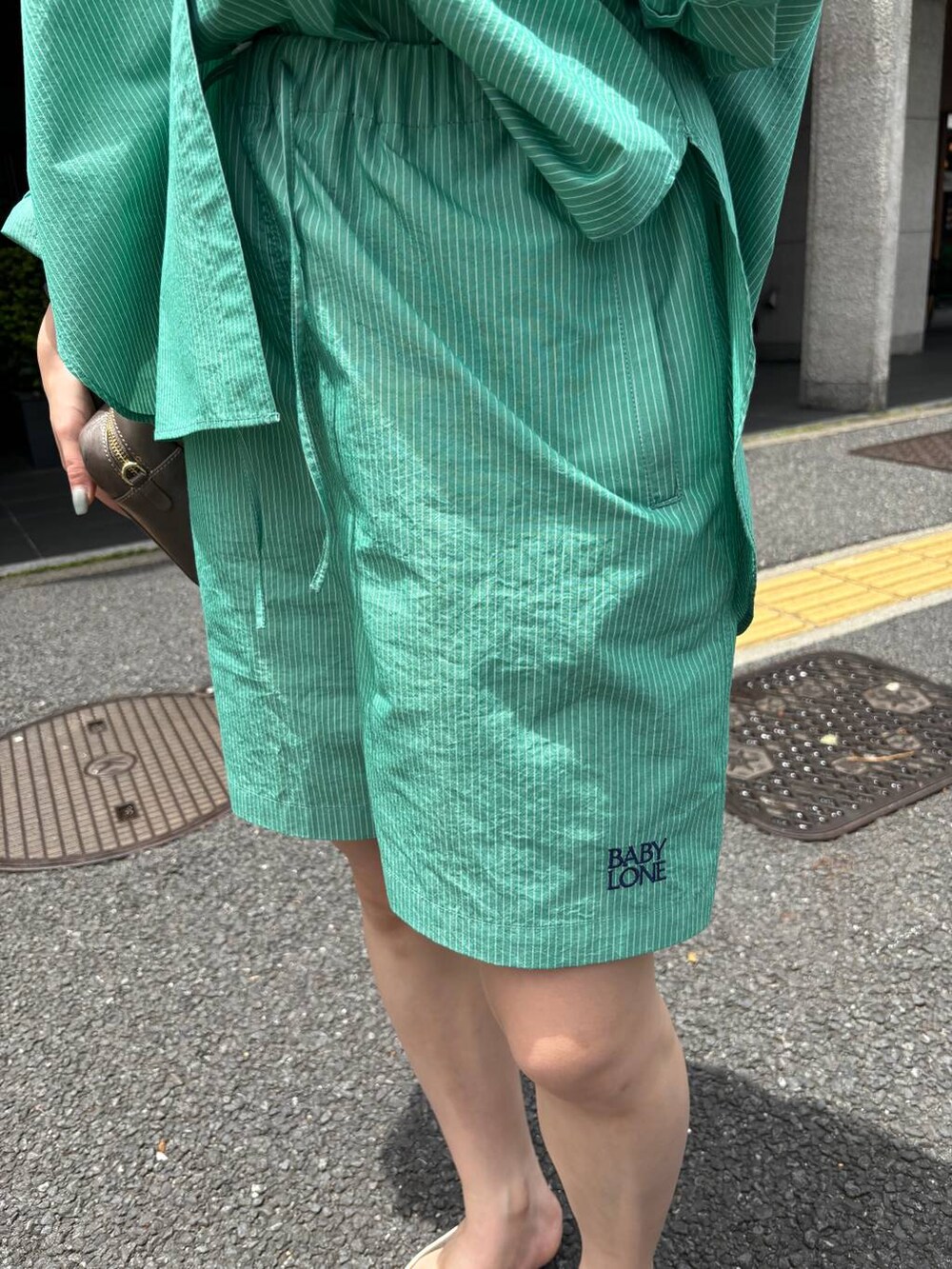 グリーン系のシャツ/ブラウス、グリーン系のその他パンツ、グレー系のショルダーバッグを着用したレディースの夏コーディネートの5枚目の写真