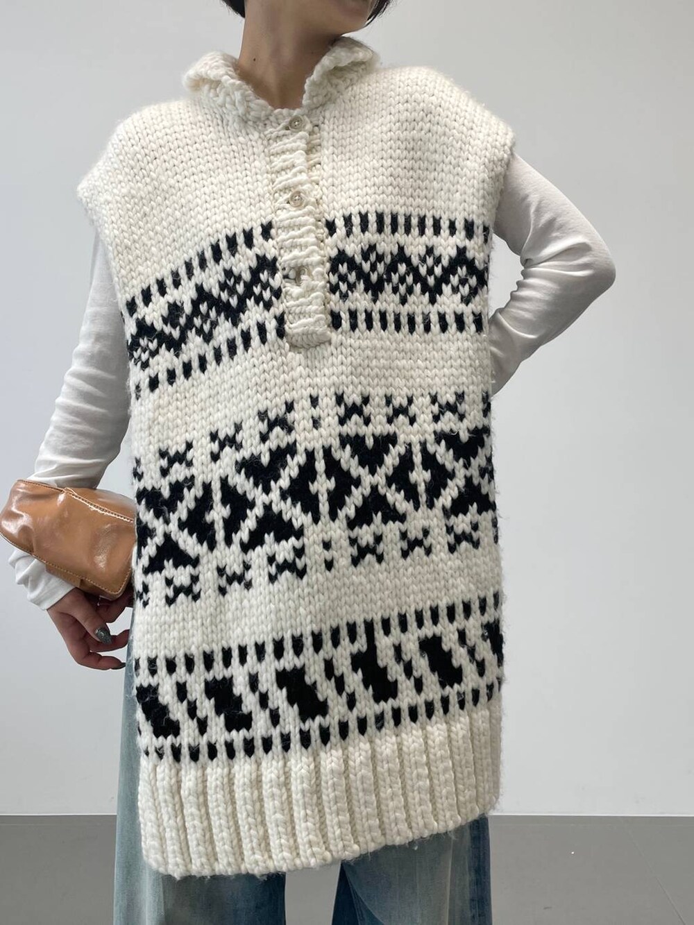 ブルー系のデニムパンツ、ホワイト系のTシャツ/カットソー、ホワイト系のベストを着用したレディースの秋コーディネートの3枚目の写真