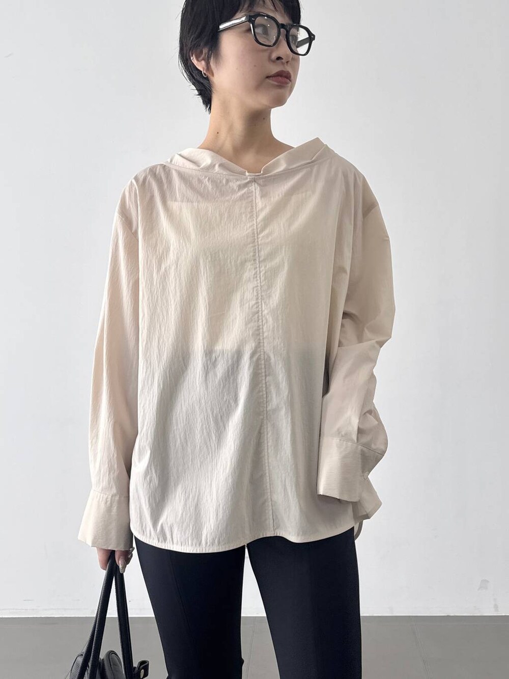 ブラック系のその他パンツ、ベージュ系のシャツ/ブラウス、ブラック系のボストンバッグを着用したレディースの春コーディネートの4枚目の写真