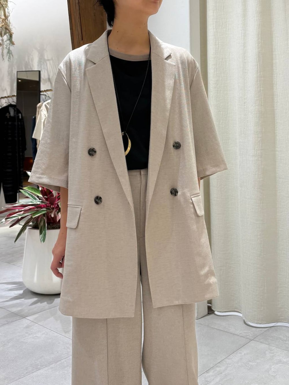 ベージュ系のスラックス、ベージュ系のテーラードジャケット、ブラック系のTシャツ/カットソーを着用したレディースの夏コーディネートの4枚目の写真