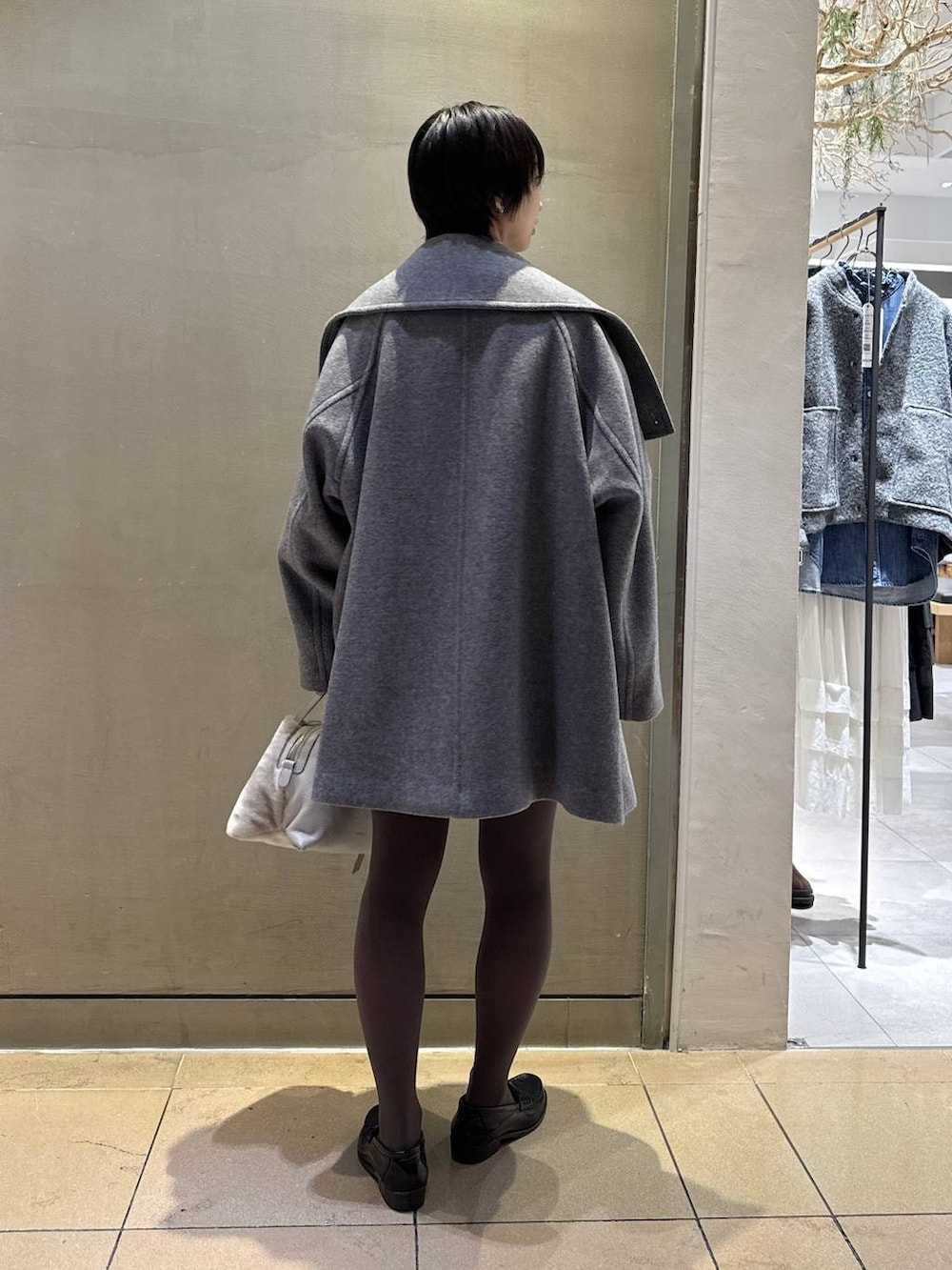 グレー系のニット/セーター、ベージュ系のハンドバッグ、グレー系のその他パンツを着用したレディースの秋コーディネートの3枚目の写真