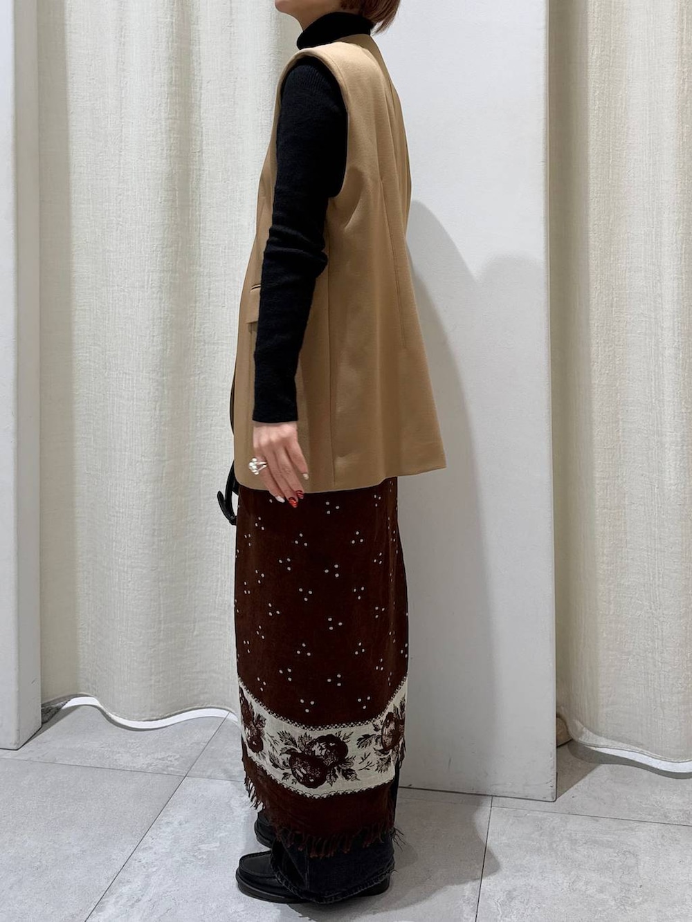 ブラック系のデニムパンツ、ベージュ系のその他アウター、ブラック系のショルダーバッグを着用したレディースの冬コーディネートの2枚目の写真