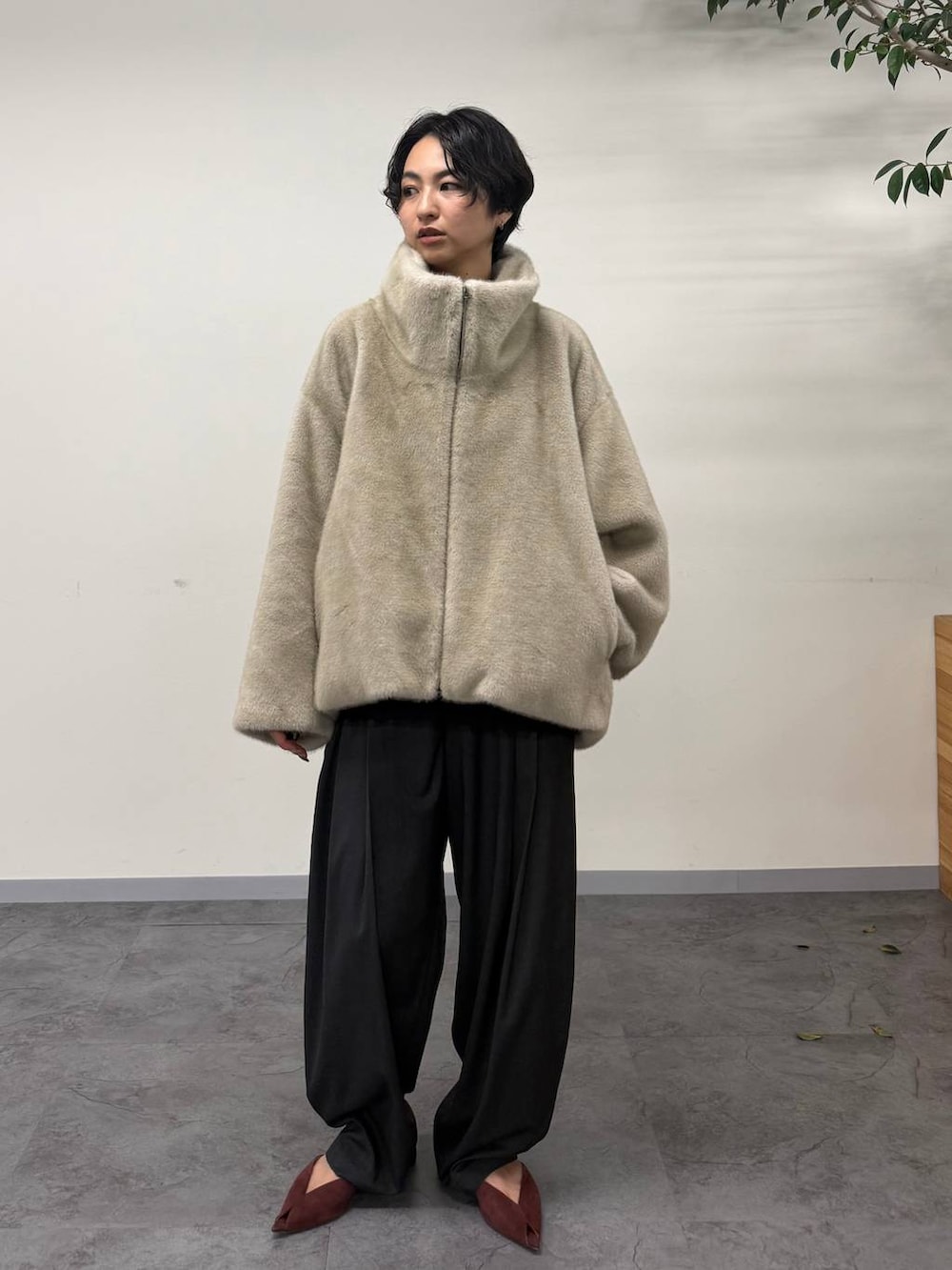 レッド系のパンプス、グレー系のその他パンツ、ベージュ系のムートンコートを着用したレディースの秋コーディネートの2枚目の写真